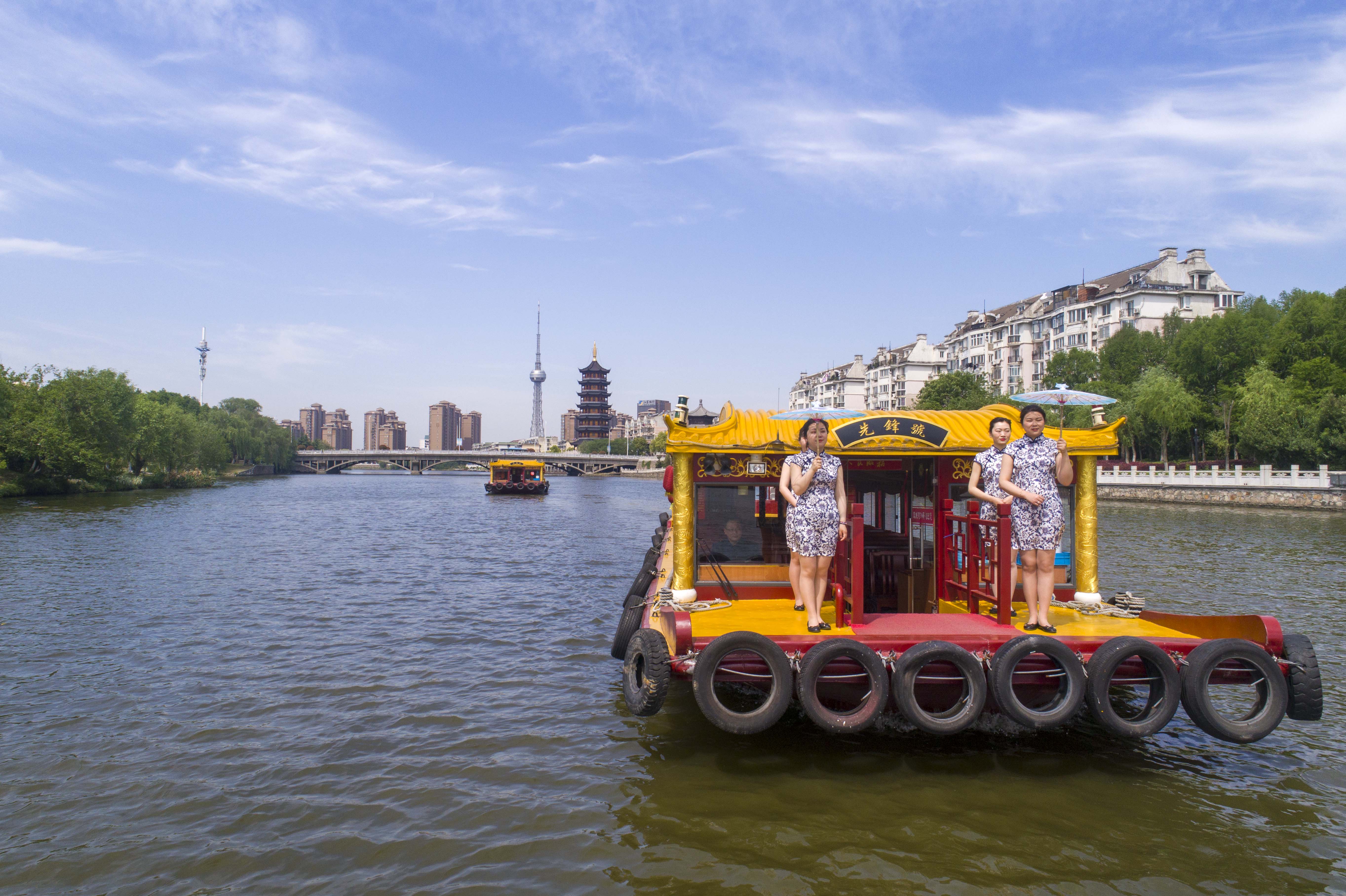 2019年5月4日,青年导游在江苏泰州凤城河景区三水湾进行旗袍走秀.